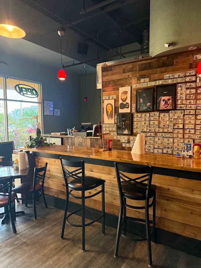 The Wicked Pub bar with its wood-paneled dollar wall and red pendant lights